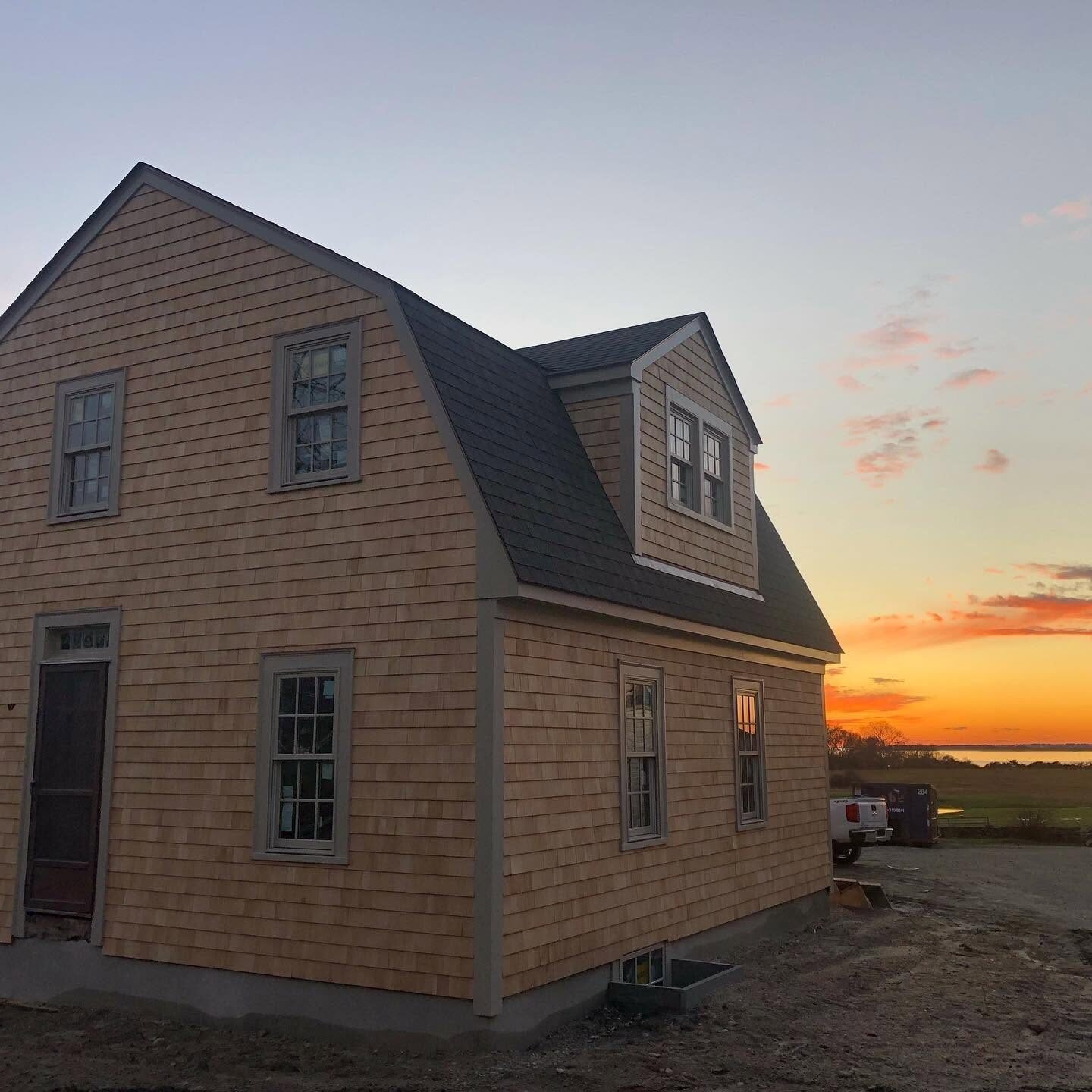 Cedar shingle gambrel home at sunset