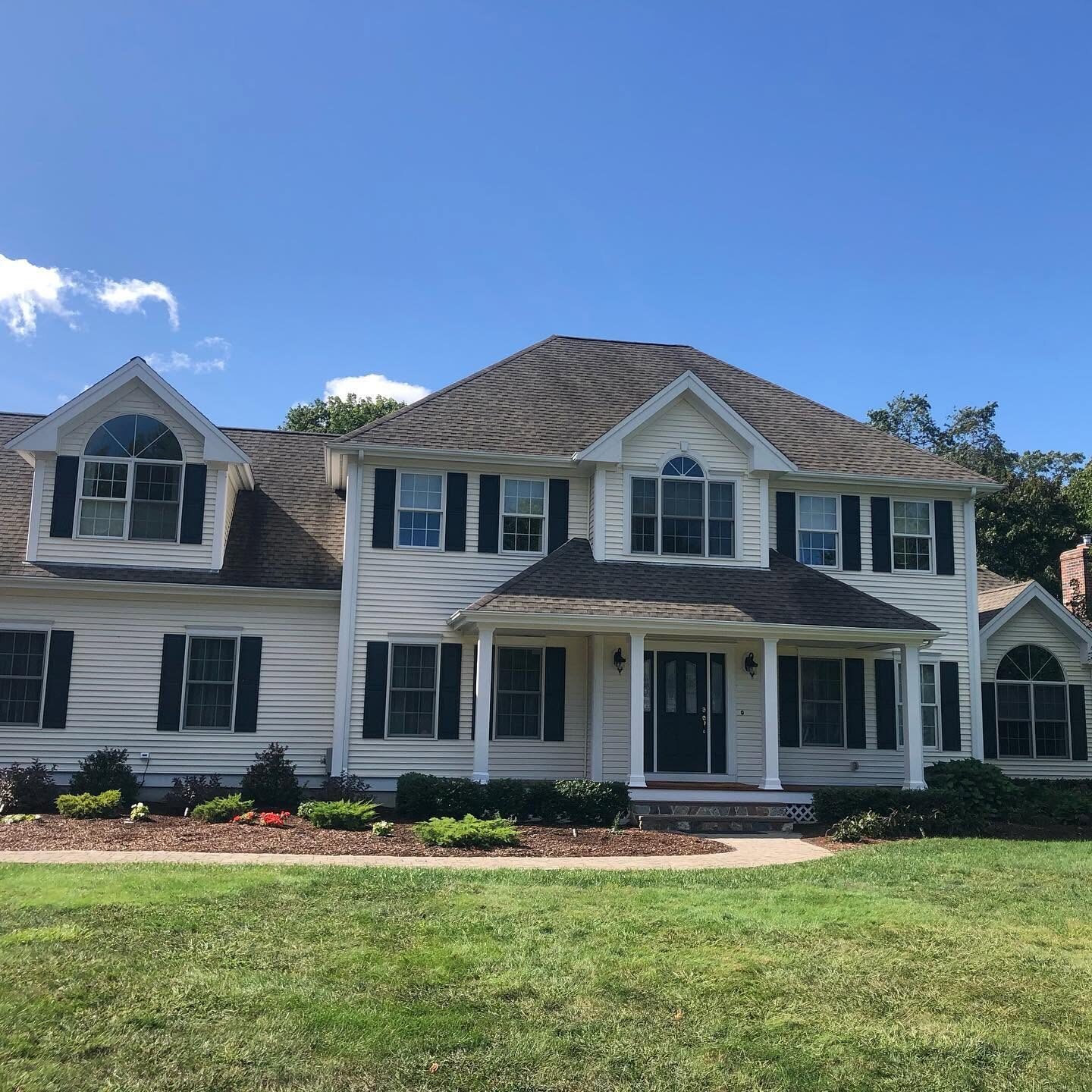 Colonial home with white siding and black shutters