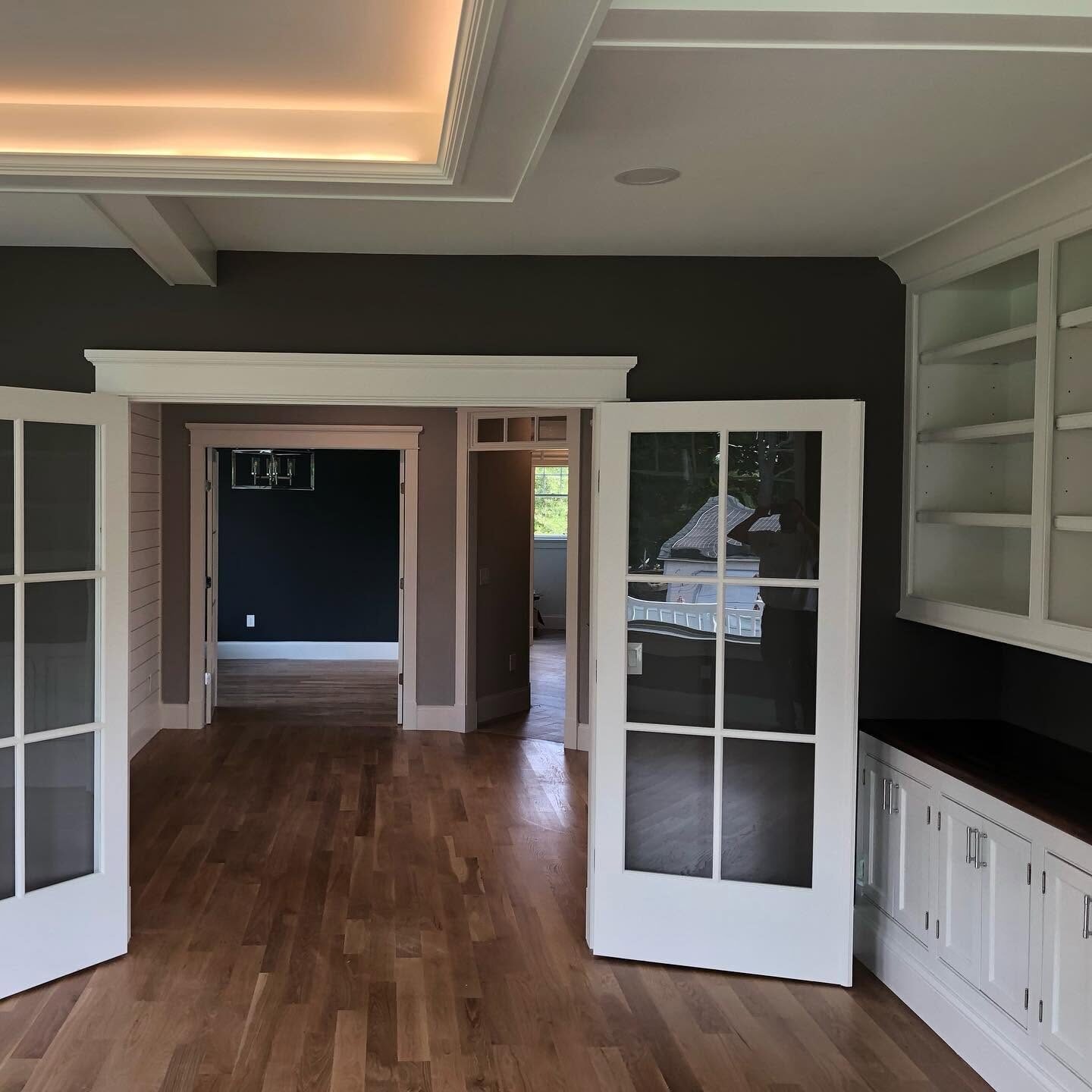 Dark painted study with white trim and French doors