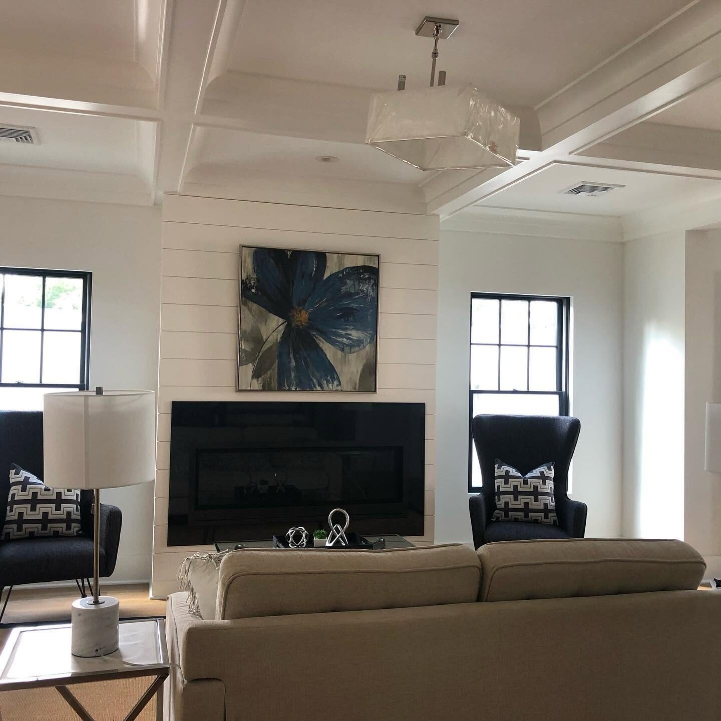 Finished living room with painted shiplap and a coffered ceiling