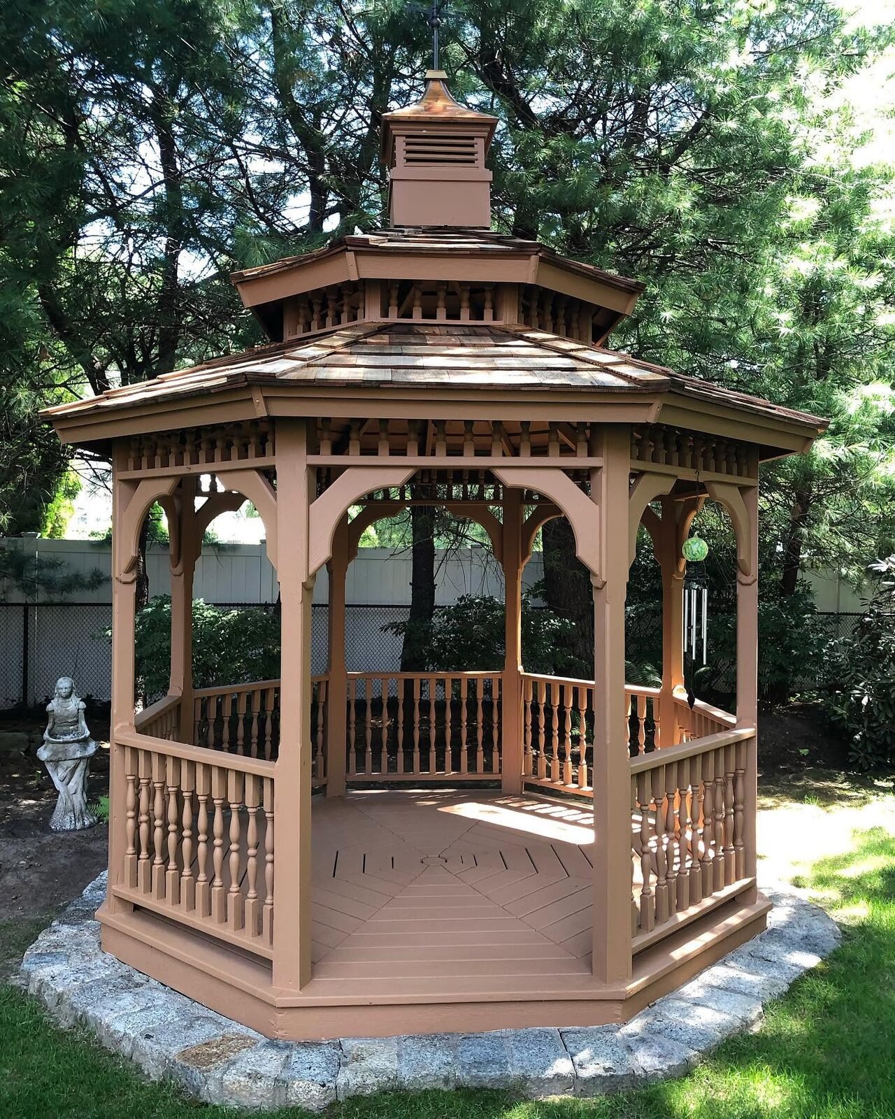 Stained gazebo in a landscaped yard
