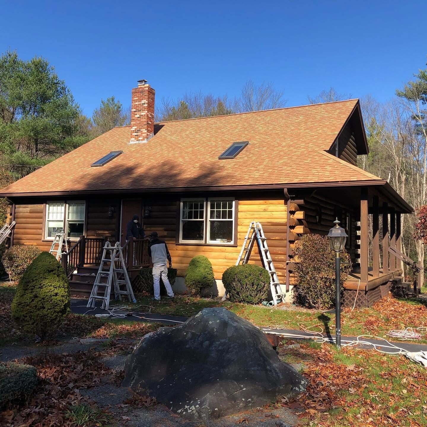Crew staining a log home exterior