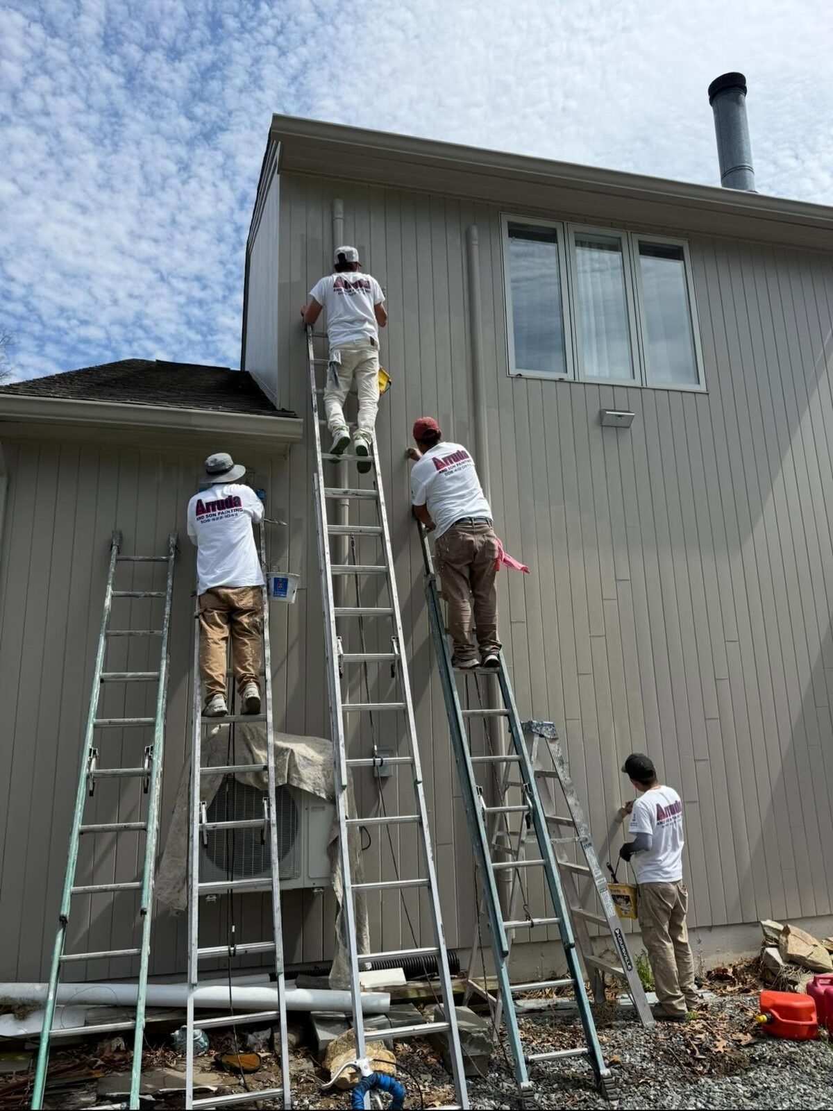 Val Arruda & Son painting crew on extension ladders painting a home exterior