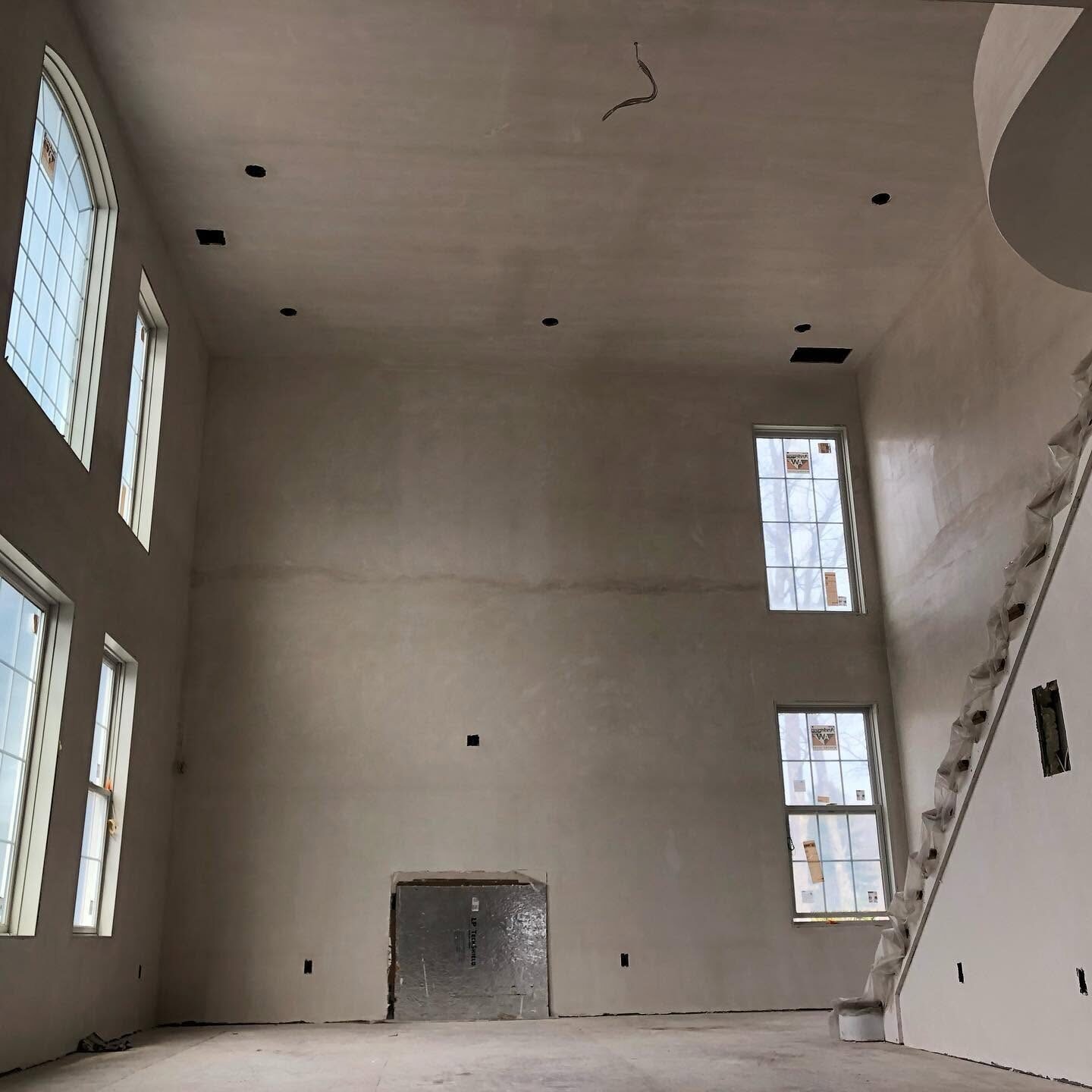 Great room with tall plaster walls ready for paint
