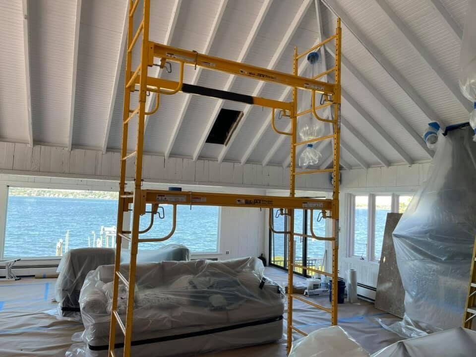 Rolling scaffold set up to paint a vaulted beadboard ceiling