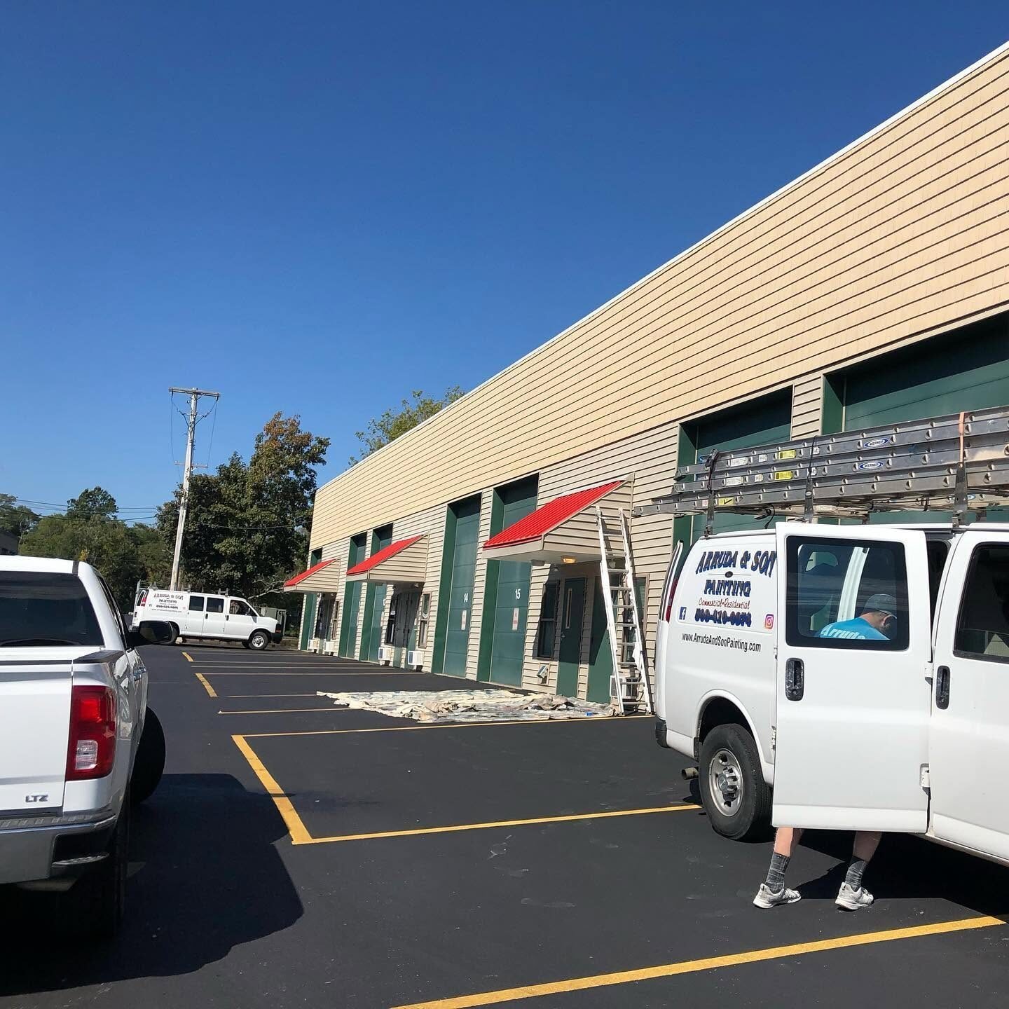 Val Arruda & Son service vans at a commercial plaza repaint