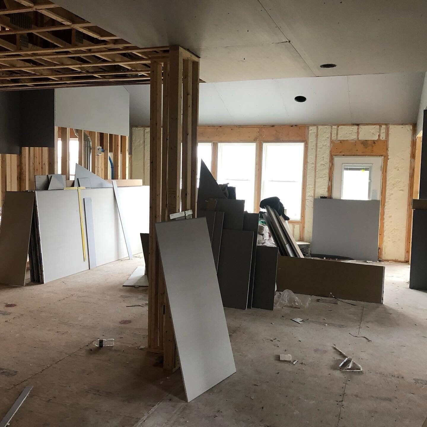 Sheetrock boards staged for hanging in an open renovation
