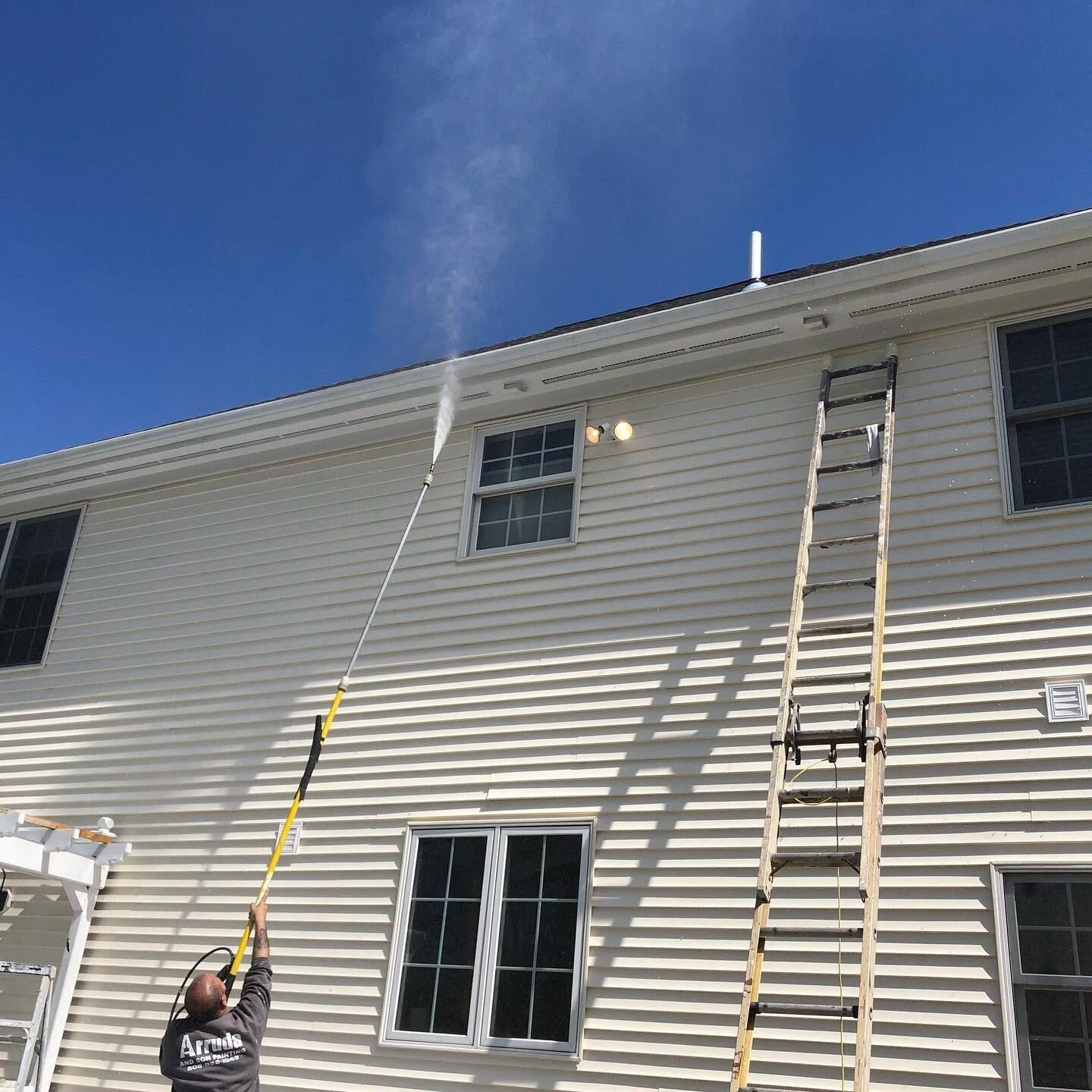 Softwashing vinyl siding on a two-story home