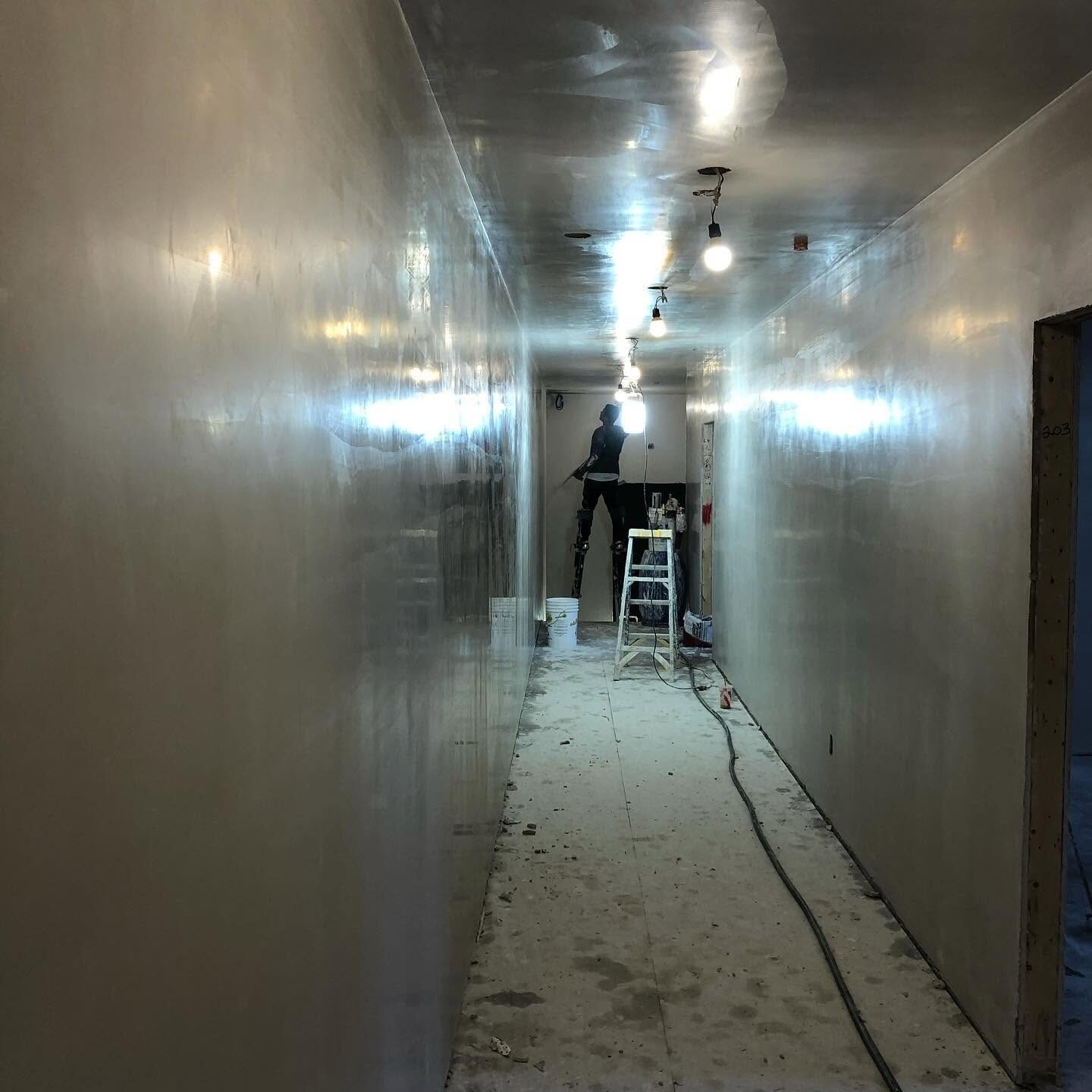 Long hallway freshly finished in veneer plaster